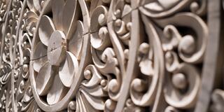 Intricate floral patterns with swirling designs are carved in a light-colored material, showcasing exquisite craftsmanship and detail.